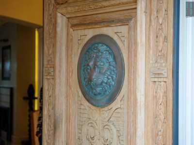 ...e dalla massiccia porta lignea di ingresso con una scura testa leonina al centro